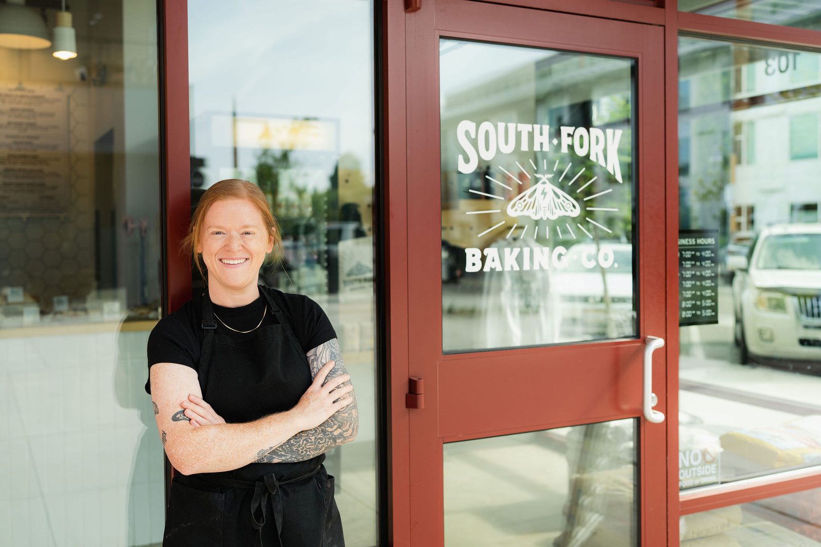 Katherine outside the red storefront door of South Fork Baking Co. in Everett